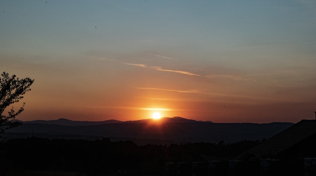 Foto gratuita impresionante vista de una puesta de sol y siluetas.