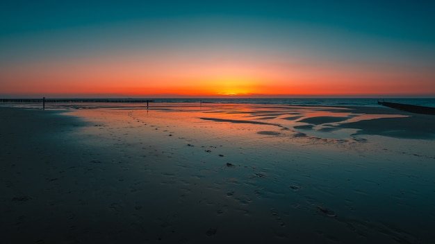 Foto gratuita impresionante vista del reflejo de la puesta de sol en el océano en domburg, países bajos