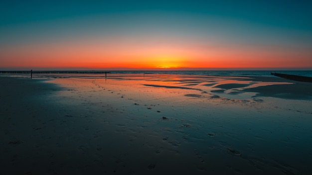 Impresionante vista del reflejo de la puesta de sol en el océano en Domburg, Países Bajos