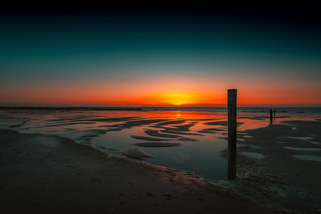 Impresionante vista del reflejo de la puesta de sol en el océano en Domburg, Países Bajos