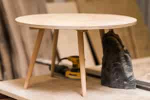 Foto gratuita incompleta pequeña mesa redonda de madera en mesa de trabajo