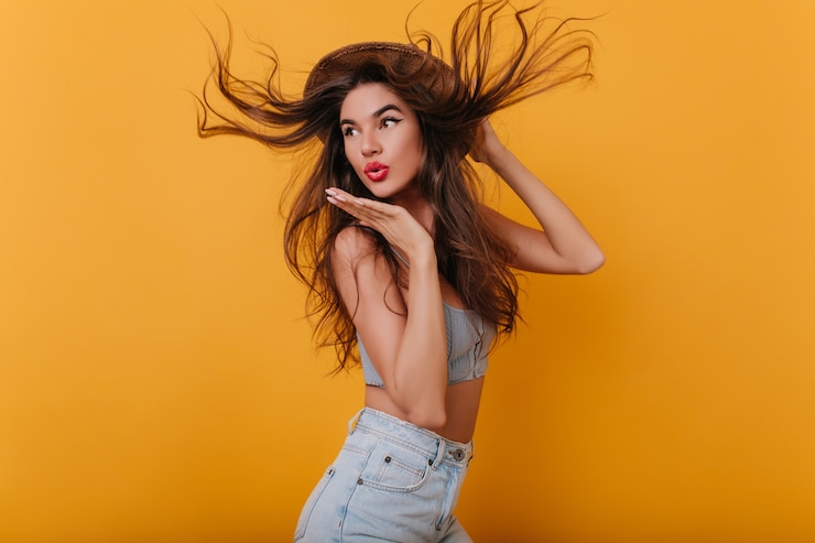 Foto gratuito increíble chica con cabello largo y liso bailando y enviando beso al aire