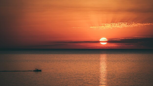 Increíble foto de un hermoso paisaje marino en una puesta de sol naranja