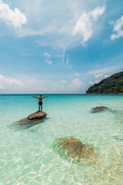 Foto gratuita increíble foto de un hombre preparándose para nadar en una playa tranquila y pacífica