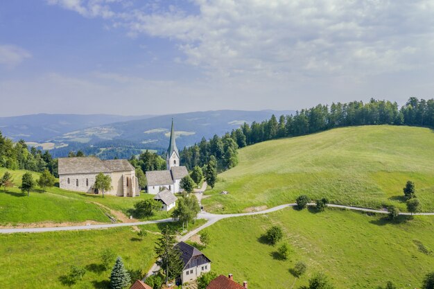 Increíble foto de la iglesia Lese en Eslovenia en un valle con un cielo nublado