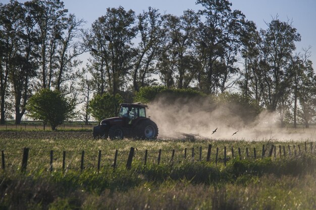 Increíble foto de un tractor trabajando en una tierra de cultivo