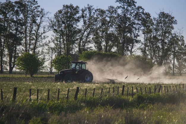 Increíble foto de un tractor trabajando en una tierra de cultivo