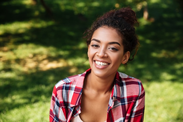 Increíble joven africana sentada al aire libre en el parque