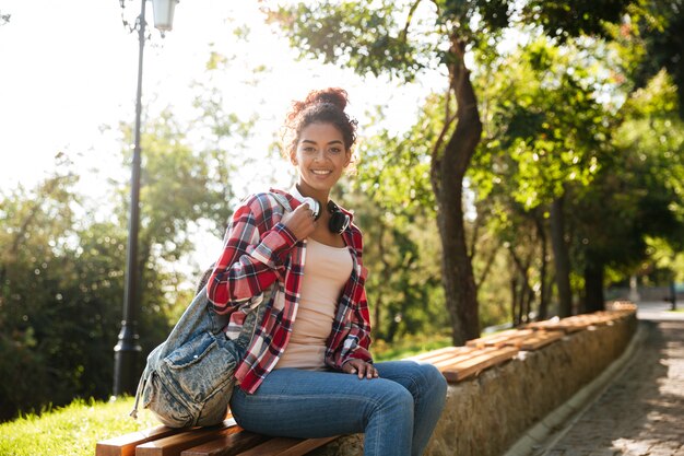 Increíble joven africana sentada al aire libre en el parque