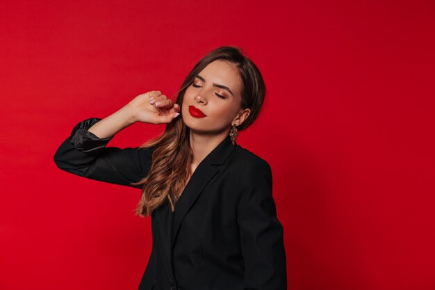 Increíble mujer feliz con labios rojos posando con los ojos cerrados sobre aislados y preparándose para celebrar el día de San Valentín