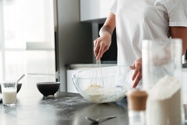 Increíble mujer joven de pie en la cocina en casa