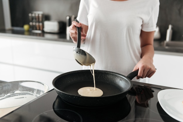 Foto gratuita increíble mujer joven de pie en la cocina en casa