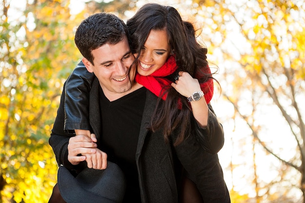 Foto gratuita increíble pareja joven divertida en el parque de otoño divirtiéndose