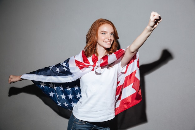 Foto gratuita increíble pelirroja joven superhéroe con bandera de estados unidos