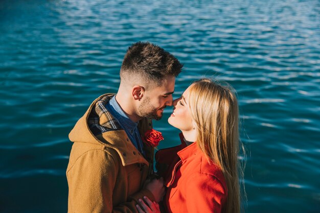 Increíbles personas alegres con rosas besándose