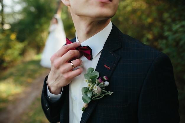 Individuo que ajusta la situación del bowtie en bosque