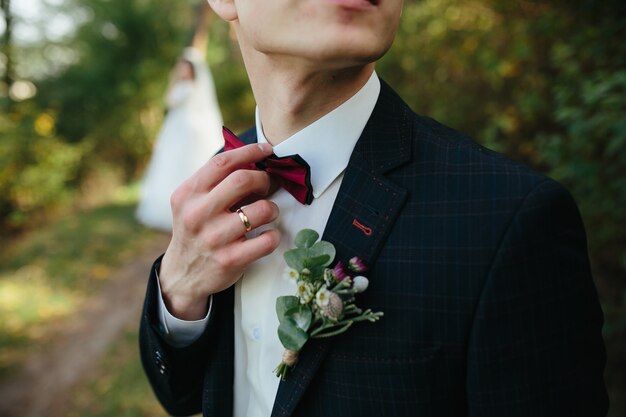 Individuo que ajusta la situación del bowtie en bosque