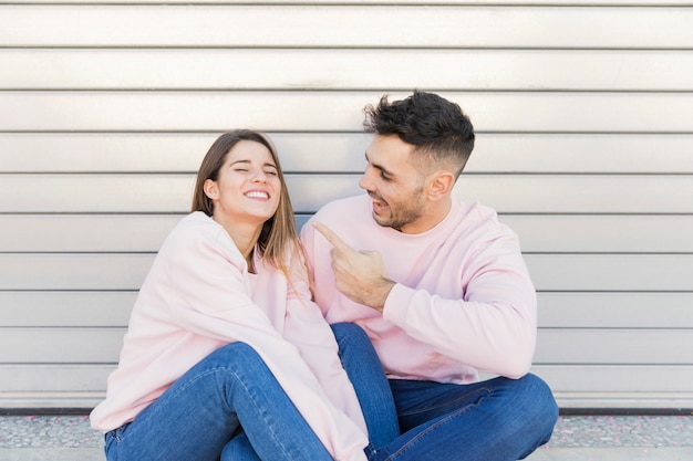 Individuo sonriente que muestra en señora feliz joven