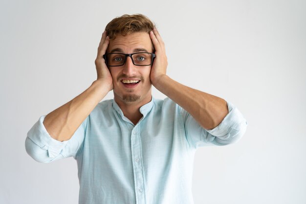 Individuo sorprendido alegre en vidrios que aprende grandes noticias asombrosas.