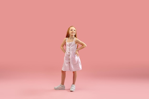 Foto gratuita infancia y sueño sobre un futuro grande y famoso chica bonita de pelo largo aislada en un fondo rosa coral