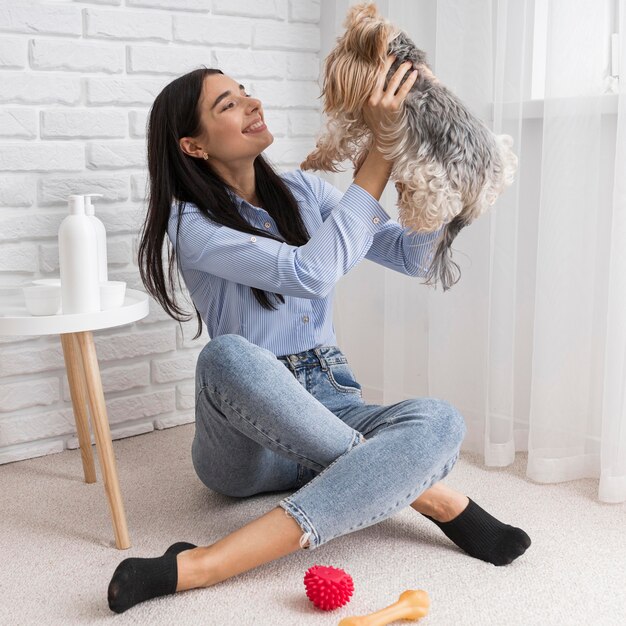 Influencer femenina en casa divirtiéndose con perro