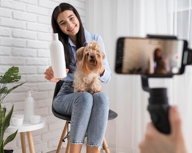 Influencer femenina en casa con perro y botella