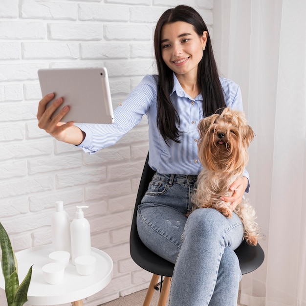 Influencer femenina en casa con perro y tableta