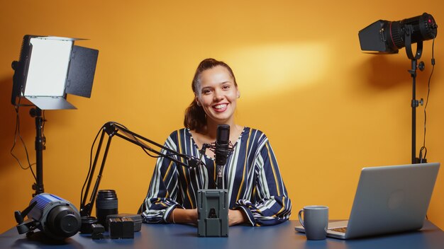 Influencer hablando sobre equipos de video profesionales en su estudio. Revisión de equipos de videografía profesional por parte del creador de contenido, una estrella influyente de los nuevos medios en las redes sociales