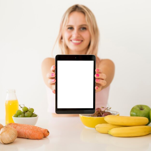 Influencer rubia enseñando tablet vacía