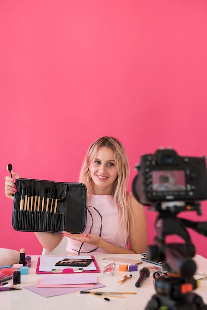 Foto gratuita influencer rubia grabando vídeo de maquillaje