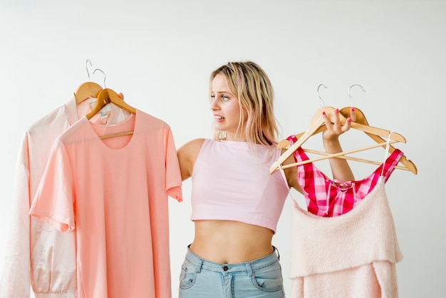 Influencer rubia sosteniendo ropa rosa