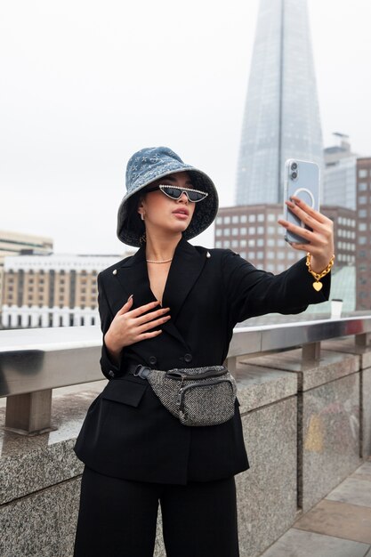 Influencer tomándose selfie en un puente de la ciudad