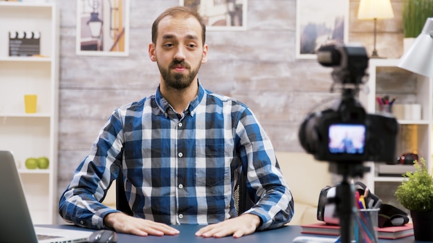 Influenciador emocionado mientras grababa para su vlog en la sala de estar. Hombre creativo famoso.