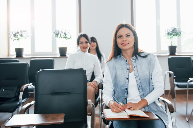 Información interesante. Grupo de personas en conferencia de negocios en el aula moderna durante el día