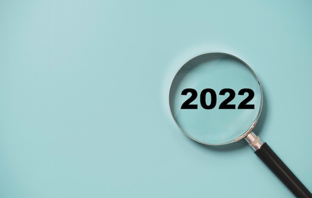 Información privilegiada del número 2022 del vidrio de la lupa sobre fondo azul para el concepto de negocio de año nuevo de enfoque. Foto Premium 