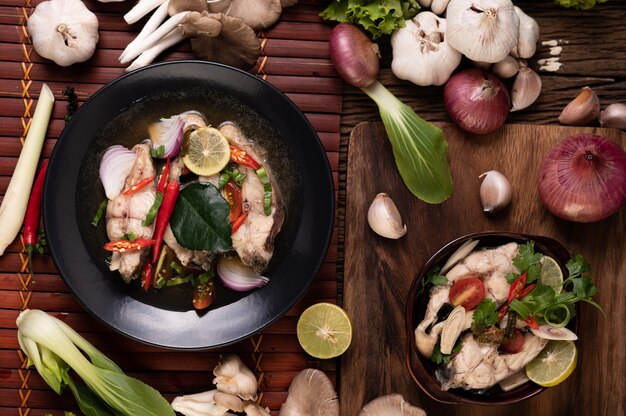 Infusión de pescado hervido con tomate, champiñones, cilantro, cebolleta y limoncillo en un bol