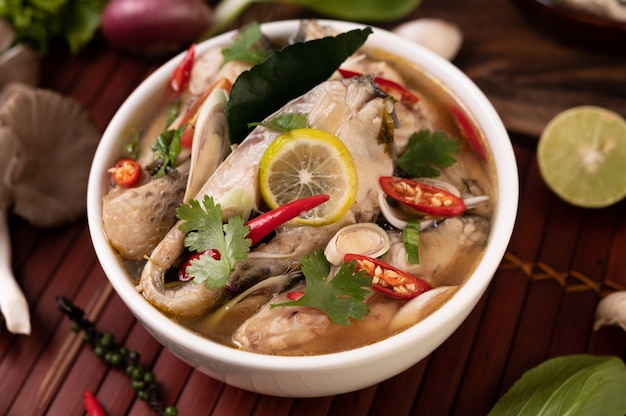 Infusión de pescado hervido con tomate, champiñones, cilantro, cebolleta y limoncillo en un bol