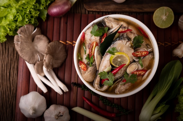 Infusión de pescado hervido con tomate, champiñones, cilantro, cebolleta y limoncillo en un bol