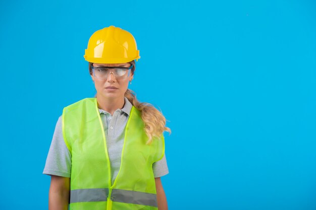 Ingeniera en casco amarillo y equipo con anteojos preventivos.