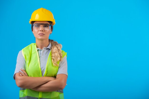 Ingeniera en casco amarillo y equipo usando anteojos preventivos.