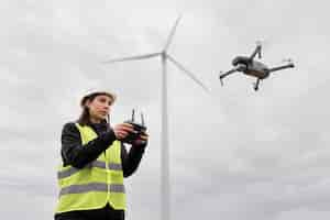 Foto gratuita ingeniera de tiro medio controlando drone