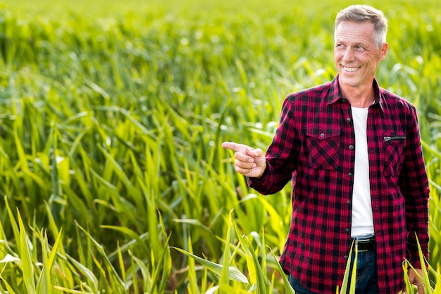 Ingeniero agrónomo sonriente que indica de lado