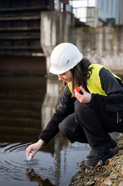 Foto gratuita ingeniero ambiental obteniendo toma completa de muestra de agua