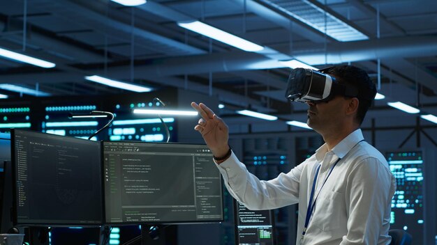 Ingeniero con auriculares de realidad virtual en el centro de datos instalando software