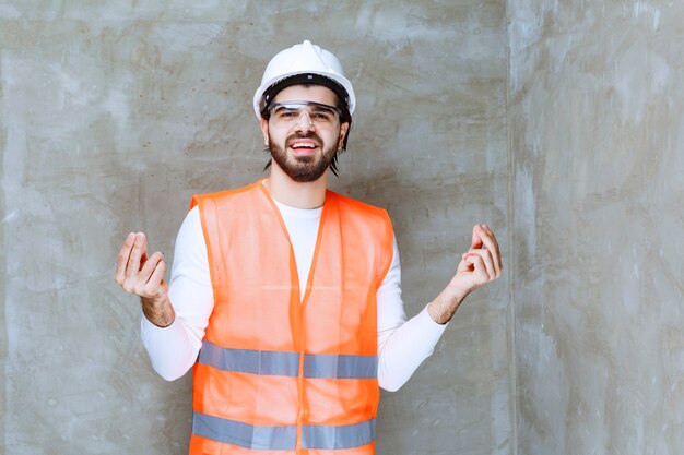 Ingeniero con casco blanco y anteojos protectores, lo que significa la calidad de un producto.