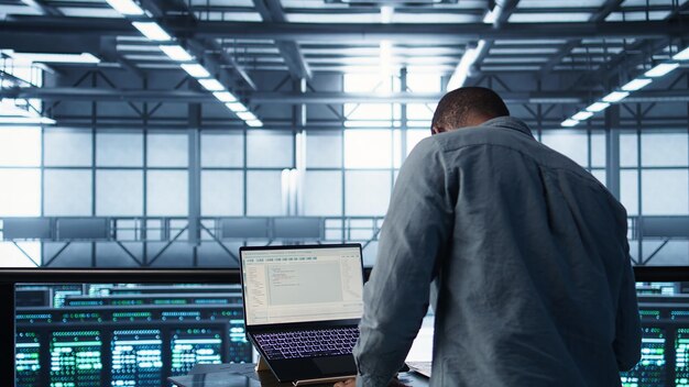 Ingeniero de centro de datos codificando en el portátil ajustando la configuración de energía
