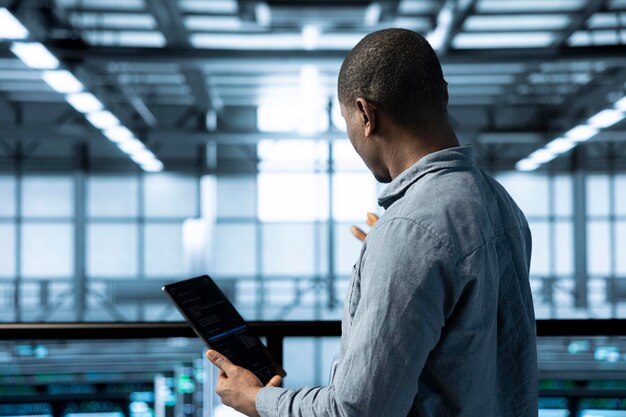 Ingeniero en un centro de datos que utiliza una computadora portátil para ajustar la configuración de gestión de energía