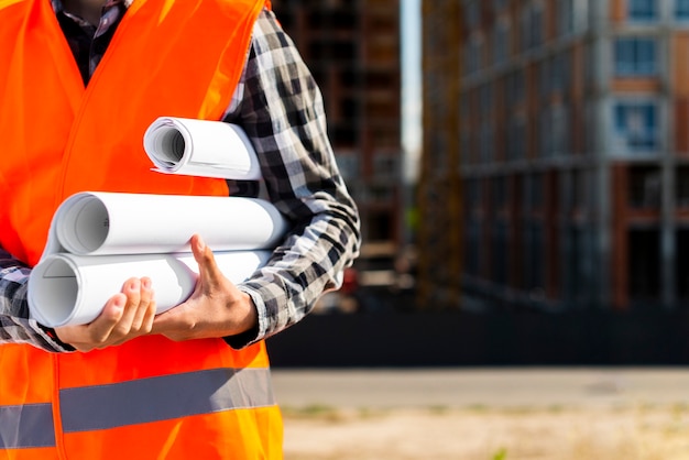 Foto gratuita ingeniero de construcción del primer que lleva a cabo planes en manos