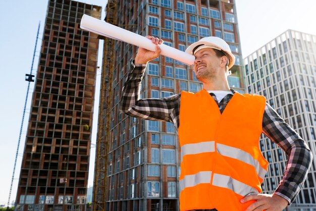 Ingeniero de construcción de vista lateral de plano medio mirando a través de planos