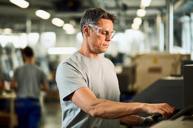 Ingeniero industrial operando una máquina CNC en la línea de producción